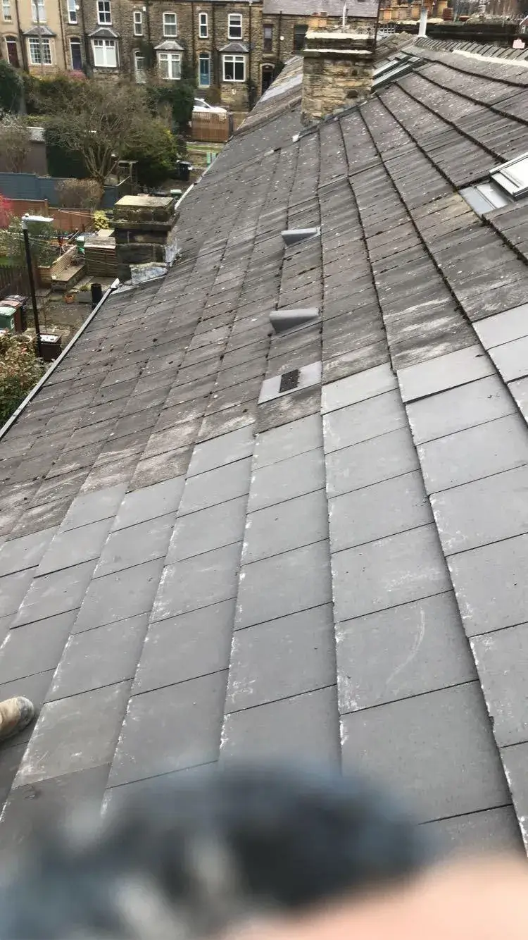 a person is taking a picture of the roof of a house